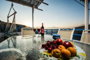 a table with a plate of fruit and a bottle of wine at Castri House in Matala