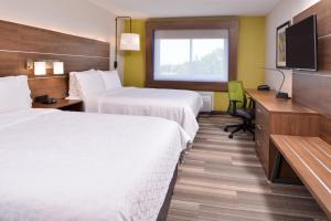 Cette chambre comprend deux lits, un bureau et une télévision. dans l'établissement Holiday Inn Express Hotel & Suites Elgin, an IHG Hotel, à Elgin