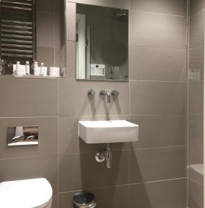 ein Bad mit einem Waschbecken und einem Spiegel in der Unterkunft No.8 Waterloo Street in Birmingham