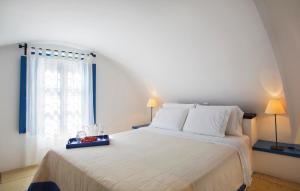 a bedroom with a large white bed with a window at Tamarix Del Mar Suites in Kamari