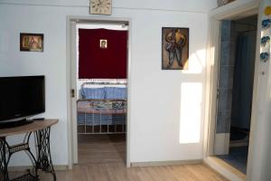 a living room with a television and a door at Castri House in Matala