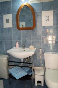 a bathroom with a sink and a toilet and a mirror at Castri House in Matala