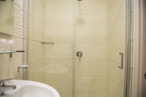 um chuveiro com porta de vidro ao lado de uma pia em Smeraldo Suite em Nápoles mais 80 fotografias