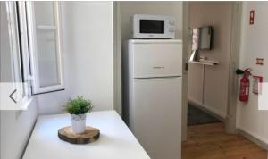 a kitchen with a refrigerator with a microwave on top of it at Love inn Bairro Alto 4 in Lisbon