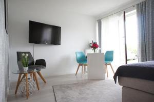 een slaapkamer met een bed en een tv aan de muur bij Ferienwohnung Lörrach Alice in Lörrach