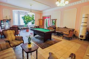 una sala de estar con una mesa de billar. en Festetich Kastélyszálló és Zsuzsanna Hotel, en Szeleste