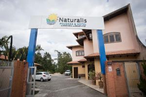 a sign for a hotel in a parking lot at Hotel Naturalis in Paranaguá