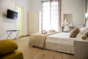 um quarto com uma grande cama branca e uma televisão em Smeraldo Suite em Nápoles