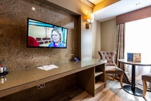 a hotel room with a flat screen tv on a wall at Fir Trees Hotel in Strabane