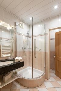 ein Badezimmer mit einer Dusche, einer Badewanne und einem Waschbecken in der Unterkunft Hotel Zimmerbräu in St. Wolfgang