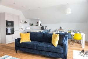 a living room with a blue couch and yellow pillows at Luxurious living in Gullane in Edinburgh