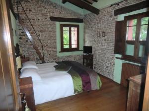 1 dormitorio con cama y pared de ladrillo en Agriturismo Case Mori, en Rímini