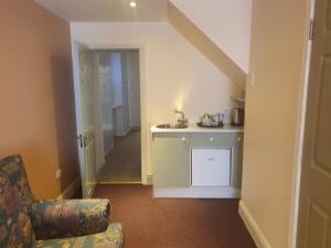 uma sala de estar com um lavatório e uma cadeira num quarto em Junior Suite Town Centre em Dungarvan