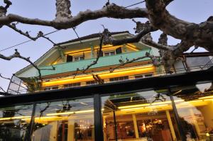 ein Gebäude hinter einem Baum gesehen wird in der Unterkunft Hôtel Restaurant Cave Bel-Air in Praz