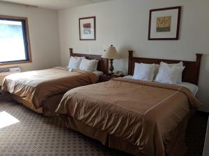 una camera d'albergo con due letti e una finestra di Boarders Inn and Suites by Cobblestone Hotels - Ripon a Ripon Altre 27 foto
