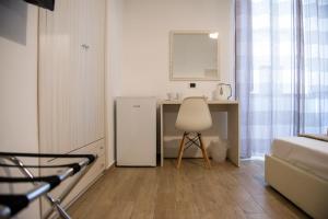 um pequeno quarto com uma secretária e um frigorífico branco em Smeraldo Suite em Nápoles