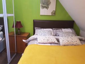 a bedroom with a yellow bed with a green wall at ZenStay in Sunderland