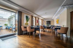 una sala da pranzo con tavoli, sedie e finestre di Hotel Suitess a Dresda