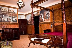 a bedroom with a canopy bed and a chair at LaCetate Boutique Hotel in Piteşti