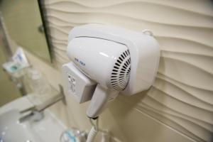 um secador de cabelo branco na parede de uma casa de banho em Smeraldo Suite em Nápoles