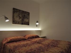 マッサ・ルブレンセにあるLA FENICE -white house- homeinsorrento-のベッドルーム1室(ベッド1台付)が備わります。壁には絵画が飾られています。