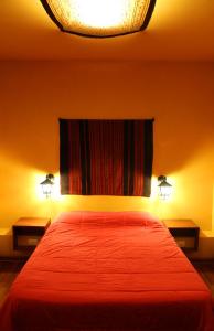 a bedroom with a red bed with two lamps at KACLLA, The Healing Dog Hostel in Lima