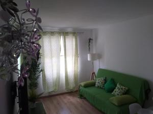 ein grünes Sofa im Wohnzimmer mit Fenster in der Unterkunft Casita verde vista mar in Parque Holandes