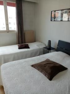 a hotel room with two beds and a window at Hôtel de la poste in Saint-Valery-en-Caux