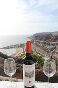 een fles wijn naast twee wijnglazen bij Casa Romantica de Balcon de Amadores in Amadores