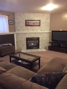 a living room with a couch and a fireplace at Newly Renovated Basement Suite! in Lethbridge