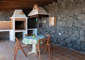 einen Tisch und Stühle in einer Küche mit einer Steinmauer in der Unterkunft Apartamento Casa Belen in Conil