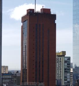 a tall building with a crane on top of it at Infinit Point Apartment in Buenos Aires