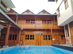 a house with a swimming pool and a balcony at Hostal La Maison Canadiense in San Ramón