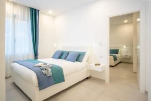 a bedroom with a large white bed with blue pillows at Appartamento Leone Rosso 1 in Sorrento