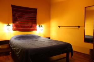 a bedroom with a bed in a room with orange walls at KACLLA, The Healing Dog Hostel in Lima