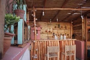 a bar in a wooden house with two chairs at Chernaki Surf Experience in Taghazout