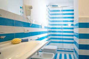 a blue and white bathroom with a tub and a toilet at Appartamento Leone Rosso 1 in Sorrento