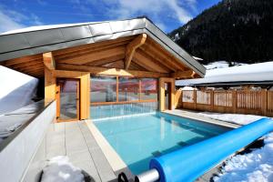 a swimming pool in a house in the snow at Résidence Néméa Le Grand Lodge in Châtel