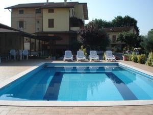 a swimming pool with chairs and a building at Bed & Breakfast Ciancaleoni in Rivotorto