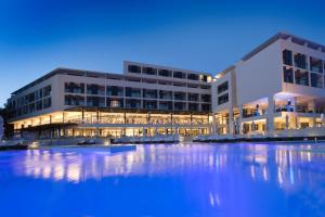 a large building with a pool of water in front of it at Hotel Parentium Plava Laguna in Poreč
