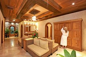 a woman is standing in a living room at The Springs Resort & Spa at Arenal in Fortuna