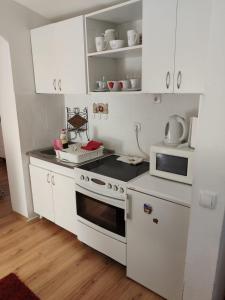 een witte keuken met een fornuis en een magnetron bij Gardos in Belgrado