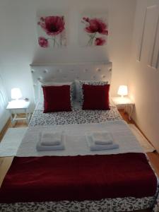 a bedroom with a large bed with red pillows at Gardos in Belgrade