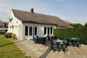 une terrasse avec des tables et des chaises en face d'une maison dans l'établissement Campanile Saint Quentin, à Saint-Quentin