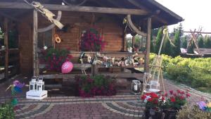 une cabane en bois avec des fleurs devant elle dans l'établissement Noclegi U Dyncyka, à Krajno Pierwsze