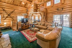 a living room with couches and a television in a log cabin at Vienna Villa - 3 Bed 3 Bath Vacation home in Shaver Lake in Shaver Lake