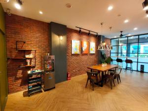 a dining room with a table and a brick wall at Burrhus in Anping