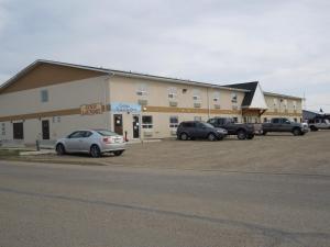 un gran edificio con coches estacionados en un estacionamiento en Walking Eagle Inn & Lodge en Rocky Mountain House