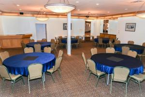 una sala de conferencias con mesas y sillas azules en Walking Eagle Inn & Lodge en Rocky Mountain House