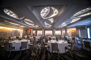 un salón de banquetes con mesas y sillas blancas en The Statler Hotel at Cornell University en Ithaca